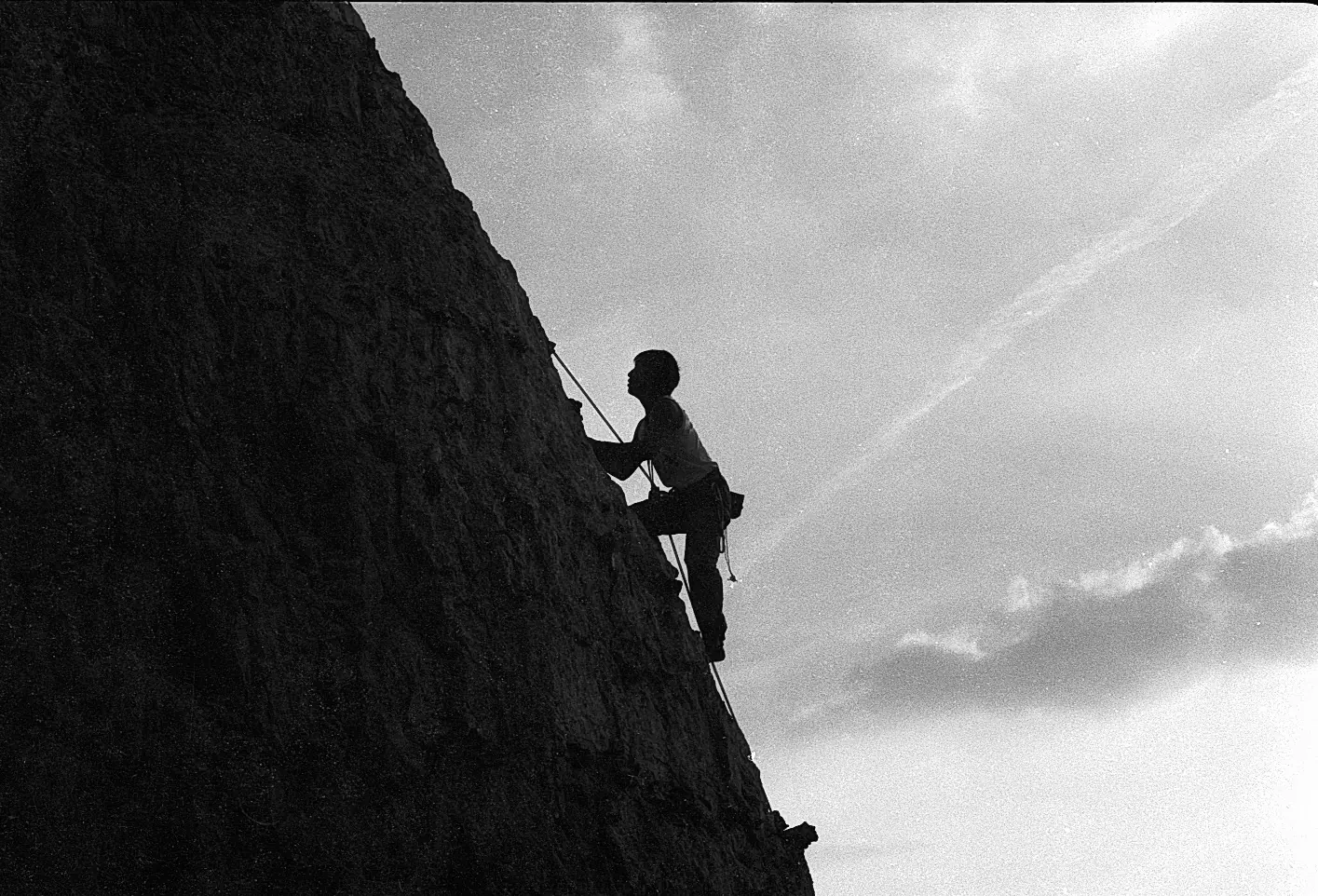 Alpiniste en silhouette sur les falaises de la Seine, La Roquette, Eure, Normandie — Nikon FM2, film noir et blanc, 1990
