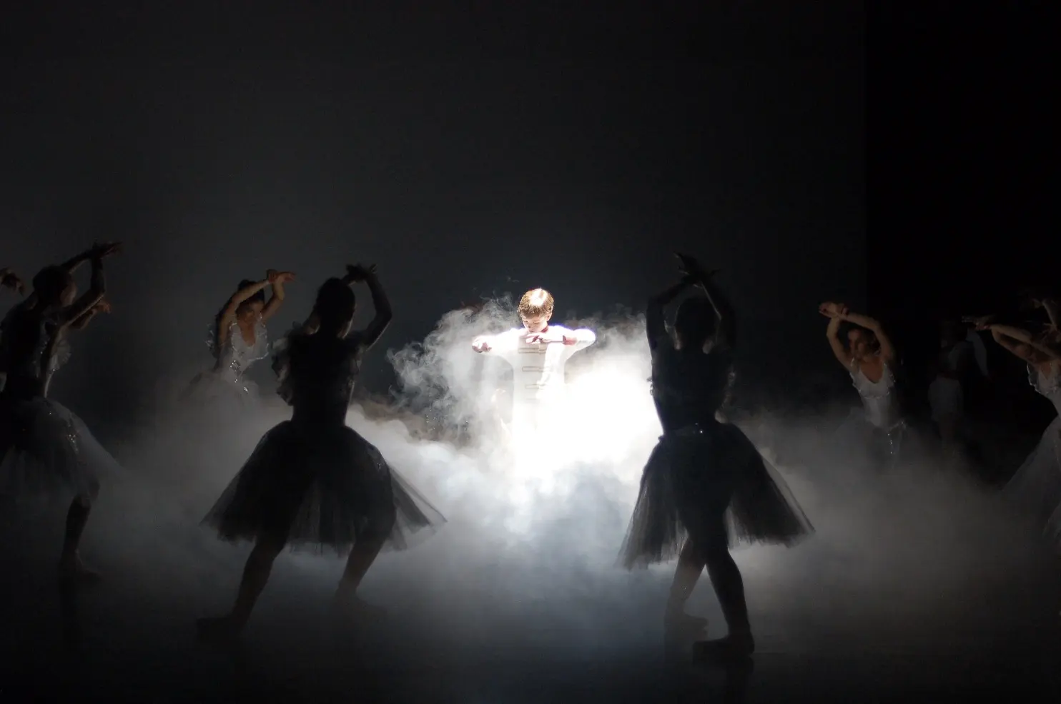 Jeune danseur au centre d'un cercle de danseuses dans la fumée de scène, spectacle Béatrice Flahault-Milza, Bezons — juin 2011